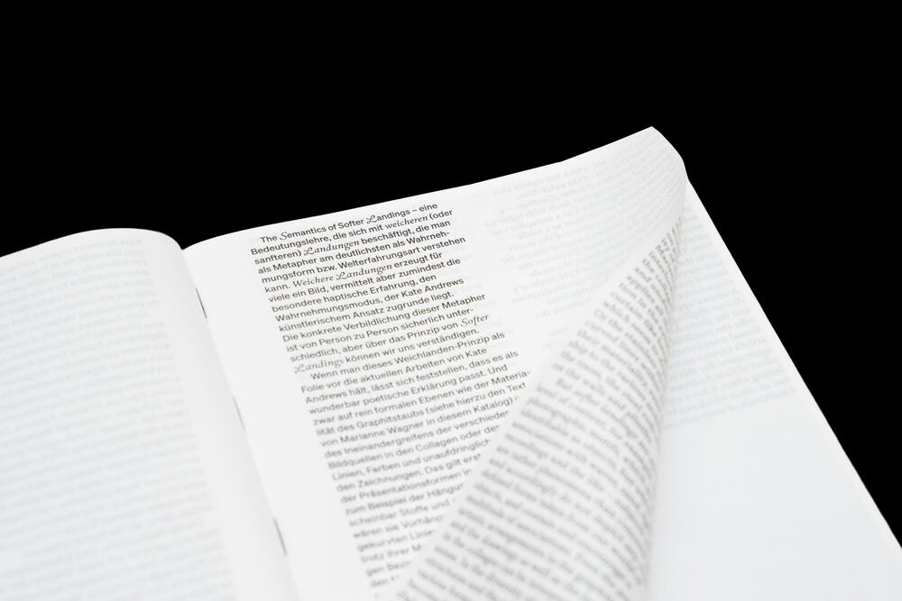 An open book with dense text in Russian or another Cyrillic script, photographed at an angle against a black background, showing two pages with justified paragraphs and what appears to be footnotes or endnotes at the bottom of the right page.